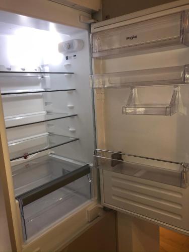 an empty refrigerator with its door open in a kitchen at Diamond Apartman in Debrecen