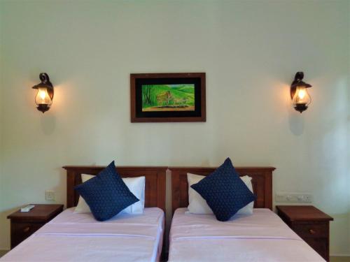 two beds in a room with lights on the wall at New Holiday Reach in Unawatuna