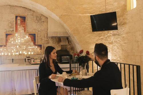 a man and woman sitting at a table in a restaurant at LUX LUCIS in Matera