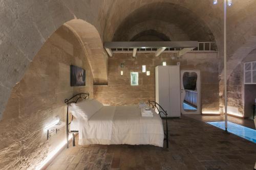 a room with a bed in a stone wall at LUX LUCIS in Matera