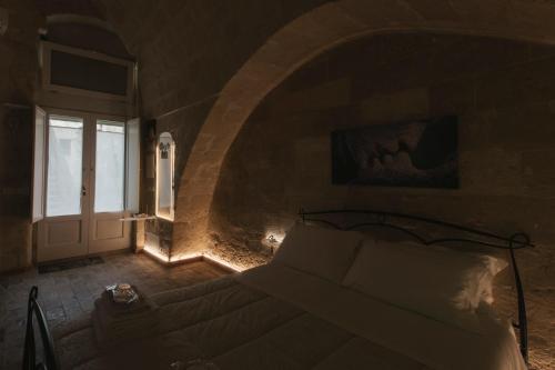 a bedroom with a bed in a room with a window at LUX LUCIS in Matera