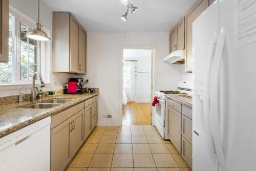 a kitchen with white cabinets and a tile floor at Landmark North Berkeley home in Berkeley