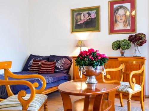 a living room with a couch and a table with flowers at Apartamenty Magiczny Kraków in Kraków