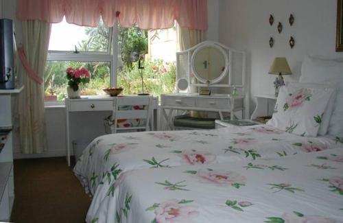 sypialnia z łóżkiem, biurkiem i oknem w obiekcie Rachel's Home From Home w Kapsztadzie