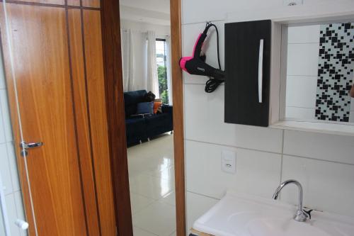 Una cocina con fregadero y puerta a una habitación. en Catuai, en Foz do Iguaçu
