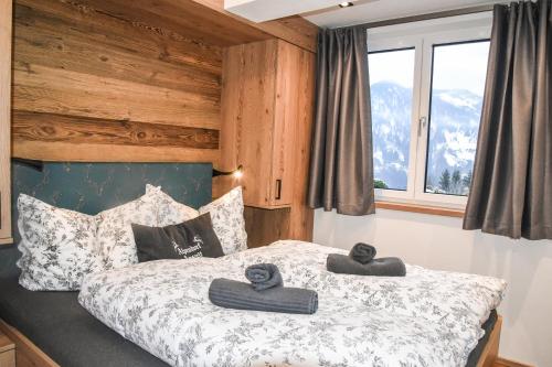a bedroom with a bed with two towels on it at Alpendorf Auszeit in Sankt Johann im Pongau