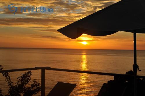 a sunset over the ocean with the sun at Infiniti Blue in Bouillante