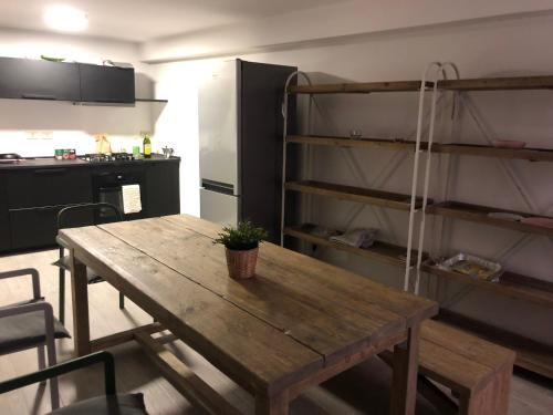 a kitchen with a wooden table and a refrigerator at Appartamento Ali&Dome centralissimo in Ancona