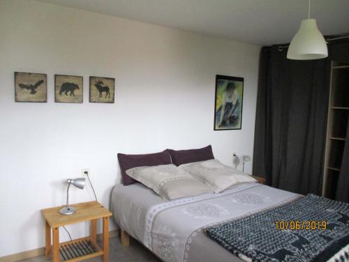 - une chambre avec un lit et des photos sur le mur dans l'établissement Entre lac et pistes, à Gérardmer