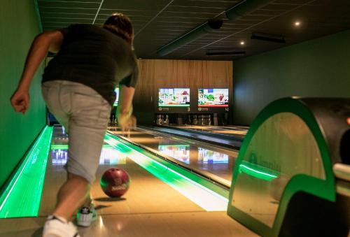 a woman playing bowling in a bowling alley at Vakantiepark Witterzomer Assen in Assen