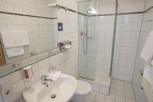 a bathroom with a sink and a shower and a toilet at Landidyll Hotel Lamm in Vaihingen an der Enz