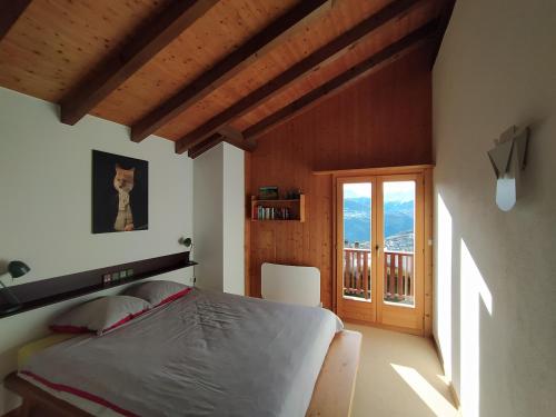 a bedroom with a bed and a balcony at Chalet Bissetrot in Crans-Montana