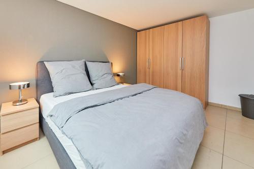 a bedroom with a large bed and a wooden cabinet at Ferienwohnung Bella Vista Premium Appartement in Bernkastel-Kues