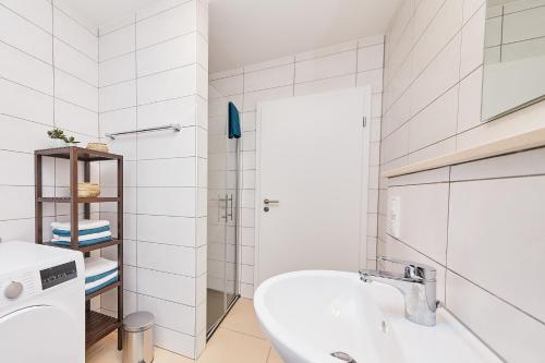 a white bathroom with a tub and a sink at Ferienwohnung Bella Vista Premium Appartement in Bernkastel-Kues