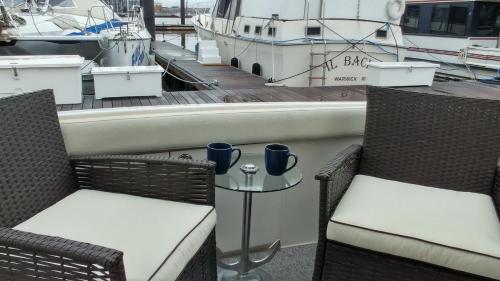 duas cadeiras e uma mesa numa doca com barcos em Little Pearl em Boston