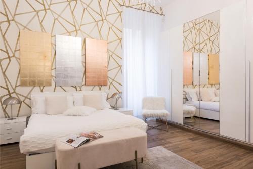 een slaapkamer met een bed, een stoel en een spiegel bij Lovely Rome Apartments in Rome
