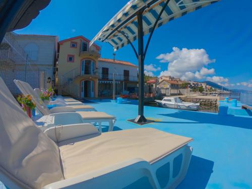 una piscina con sedie a sdraio e ombrellone di Porto Del Sole apartments a Tivat