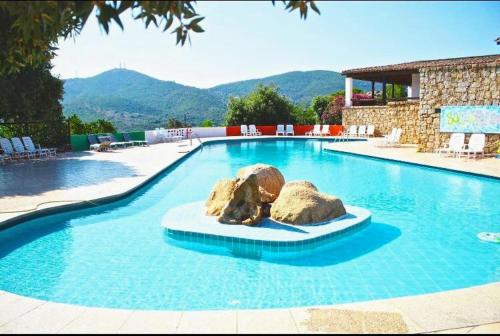a swimming pool with two rocks in the middle of it at CasaTurchese-Colline Costa Smeralda in Olbia