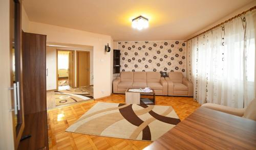 a living room with a couch and a table at Apartament Alessi in Haţeg