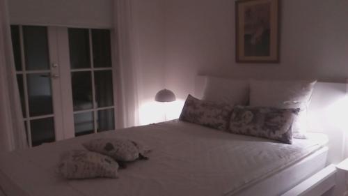 um quarto com uma cama branca e 2 almofadas em Hos Anna em Roskilde