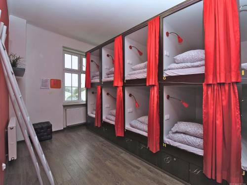 a room with red curtains and bunk beds at 3 City Hostel in Gdańsk