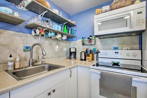a kitchen with a sink and a microwave at Stunning Makaha Condo with Pool Access and Ocean View! in Waianae