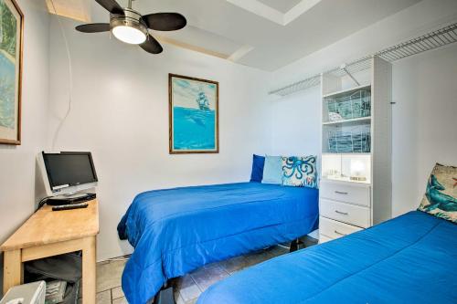 a bedroom with two beds and a desk with a computer at Stunning Makaha Condo with Pool Access and Ocean View! in Waianae