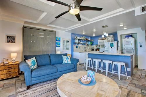 a living room with a blue couch and a table at Stunning Makaha Condo with Pool Access and Ocean View! in Waianae