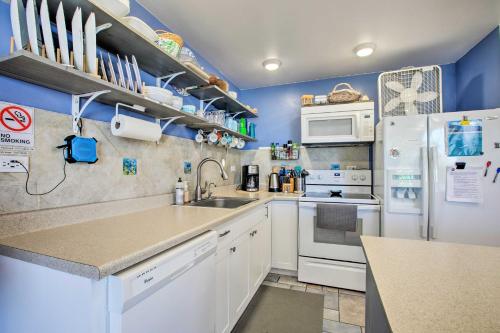 a kitchen with white appliances and blue walls at Stunning Makaha Condo with Pool Access and Ocean View! in Waianae