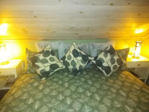 a bed with four pillows on it in a room at Roliga semestrar i Åhus! in Åhus