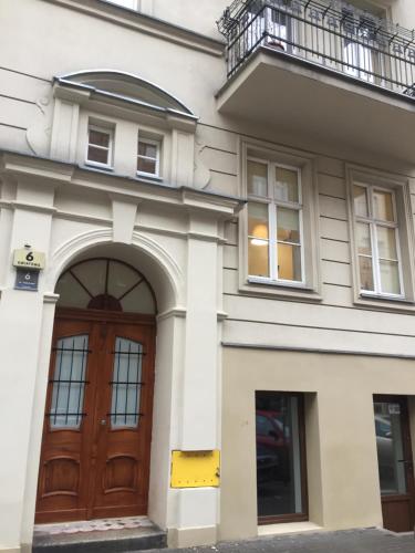een gebouw met een houten deur en een balkon bij Apartament Kwiatowa in Poznań