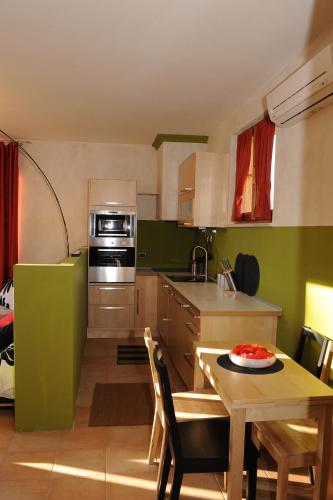 a kitchen with a table and a kitchen with green at La Terrazza in Spoleto