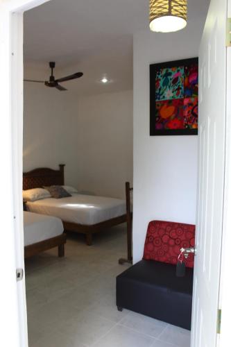 a room with two beds and a couch in it at Hotel Casona Margot in Valladolid