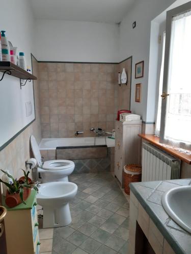 a bathroom with two toilets and a tub and a sink at Da Marisetta a San Severino Marche in San Severino Marche