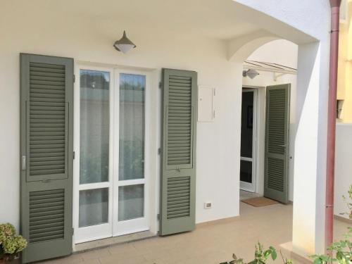 a facade of a house with green doors at Villetta Marina in Marciana Marina