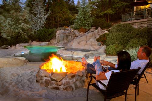 a man and woman sitting around a fire pit in a backyard at Bella Vista Bed and Breakfast in Coloma