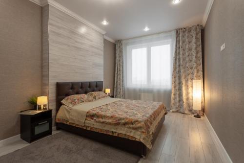 a bedroom with a bed and a large window at 3к семейные апартаменты с видом на акваторию in Kazan