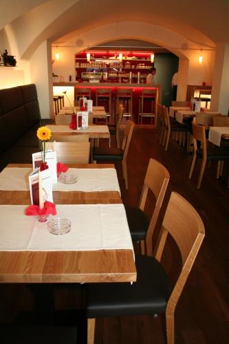 a restaurant with tables and chairs and a bar at Hotel Munde in Telfs