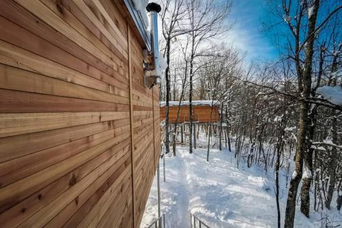 a wooden fence in the snow next to trees at Treehouse Lika1 in Gospić