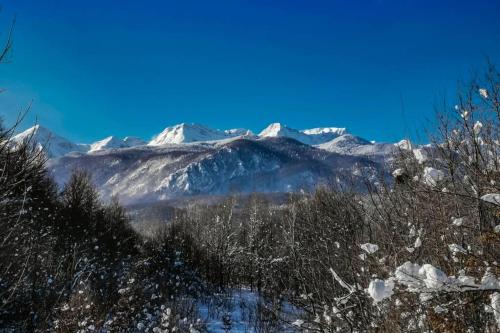 a snow covered mountain range with snow covered mountains at Treehouse Lika1 in Gospić