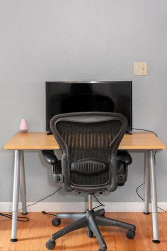a desk with a chair in front of a computer monitor at Large 1 Bedroom Apartment, Home Theater, Fireplace in Berkeley
