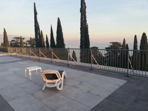 a chair and a table on a balcony with trees at Residence Villa Alba room nr 415 in Gardone Riviera