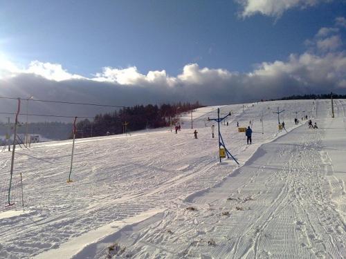 a group of people skiing down a snow covered slope at Penzión Fistra in Fričkovce