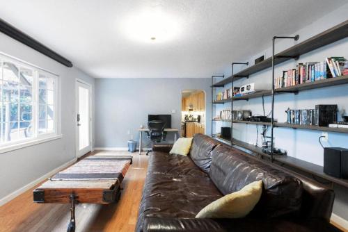 a living room with a leather couch and a coffee table at Large 1 Bedroom Apartment, Home Theater, Fireplace in Berkeley
