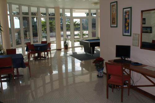 a living room with a piano and tables and chairs at Hotel Minerva in Brindisi