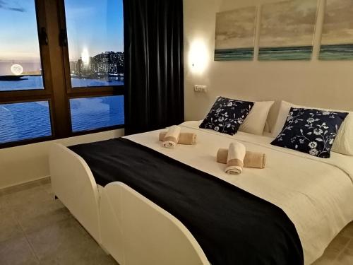 Cette chambre comprend un grand lit blanc et une fenêtre. dans l'établissement Doñana12 by SunHousesCanarias, à Patalavaca