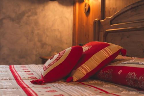 2 almohadas rojas y blancas sentadas en una cama en Altavilla Locanda E Tipica Trattoria, en Bianzone
