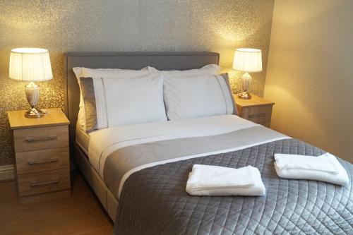 a bedroom with a large bed with two night stands at Ricky Road Guest House - Premium in Watford