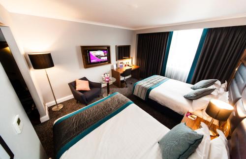 a hotel room with two beds and a tv at Crowne Plaza Leeds by IHG in Leeds