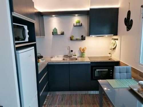 a kitchen with blue cabinets and a sink at Cantinho do Ilhéu in Ponta Delgada